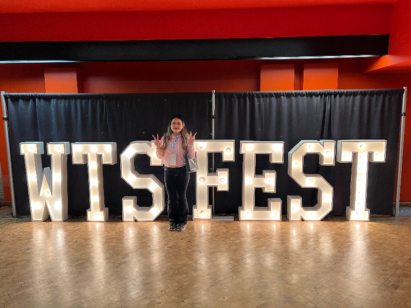 Kim in front of the ‘WTSFEST’ sign